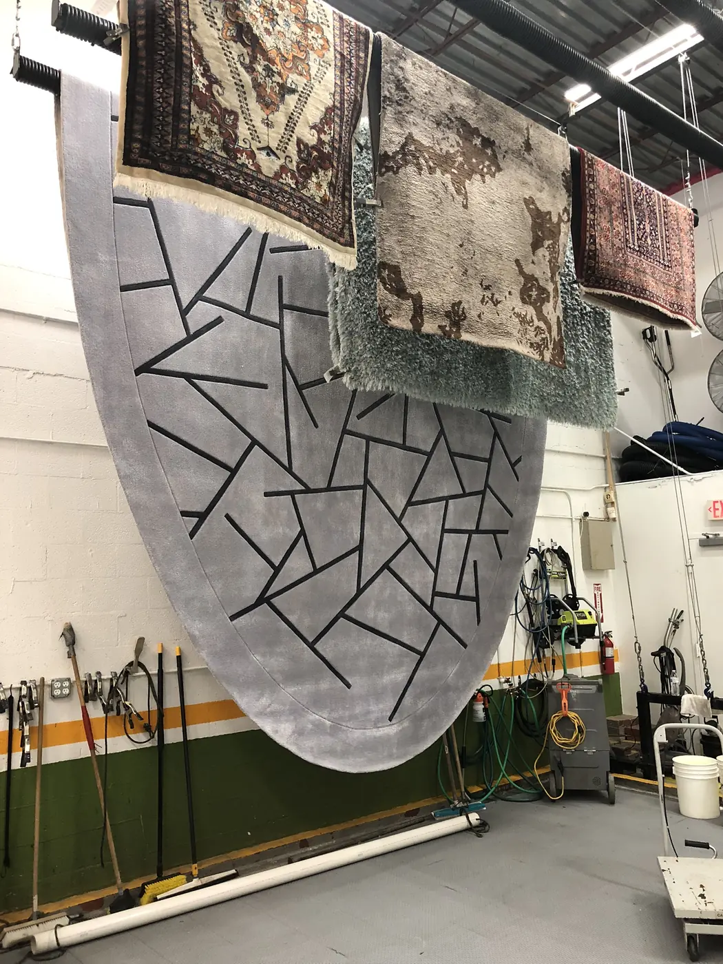 Modern black and white patterned rug hanging in the plant
